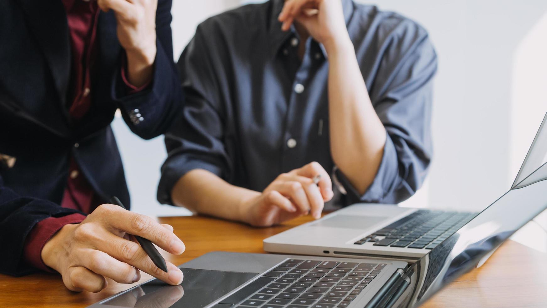 colegas asiáticos homem e mulher discutindo e trabalhando com laptop na mesa de escritório no escritório foto