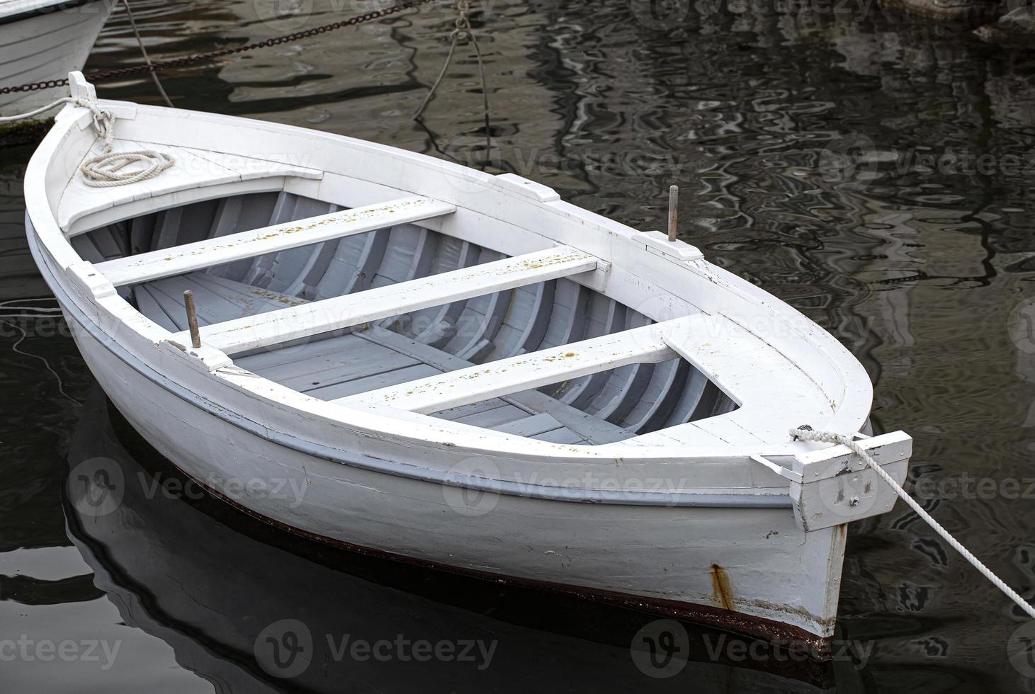 barco ancorado branco em um rio é oceano com corda e reflexão. foco seletivo foto