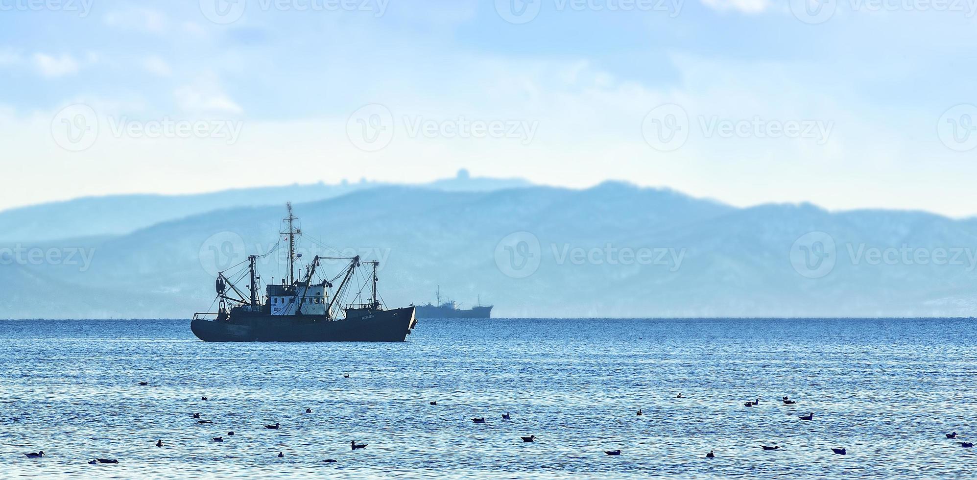 barco de pesca na manhã cinzenta no oceano pacífico ao largo da costa da península de kamchatka foto