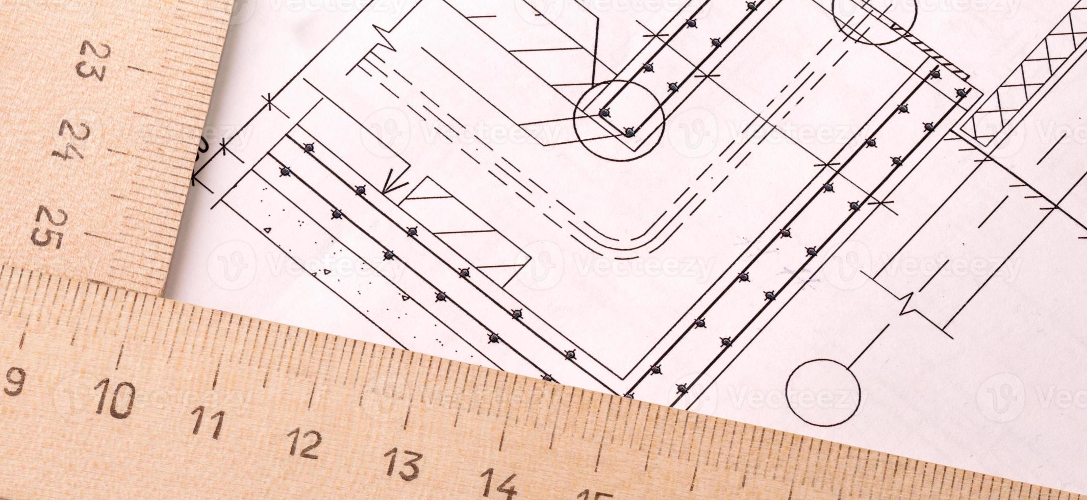 projeto arquitetônico, papel de desenho e régua de madeira em uma mesa de perto foto