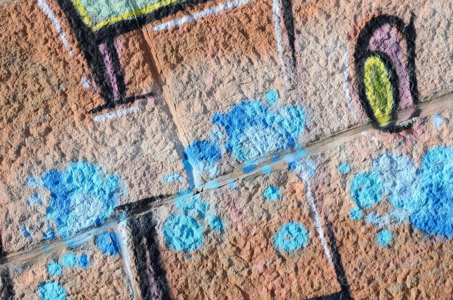 fragmento de desenhos de grafite. a velha parede decorada com manchas de tinta no estilo da cultura da arte de rua. textura de fundo colorido em tons quentes foto