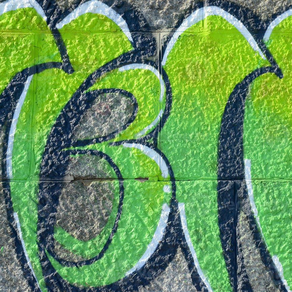 fragmento de desenhos de grafite. a parede antiga decorada com manchas de tinta no estilo da cultura da arte de rua. textura de fundo colorido em tons de verde foto