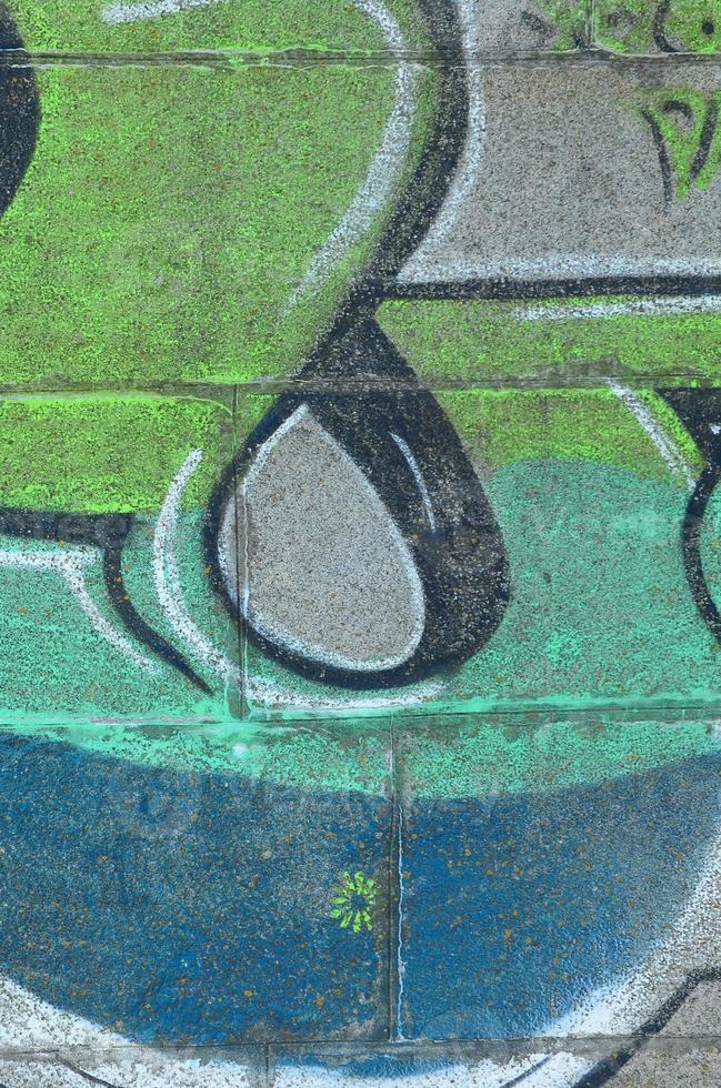 fragmento de desenhos de grafite. a parede antiga decorada com manchas de tinta no estilo da cultura da arte de rua. textura de fundo colorido em tons de verde foto