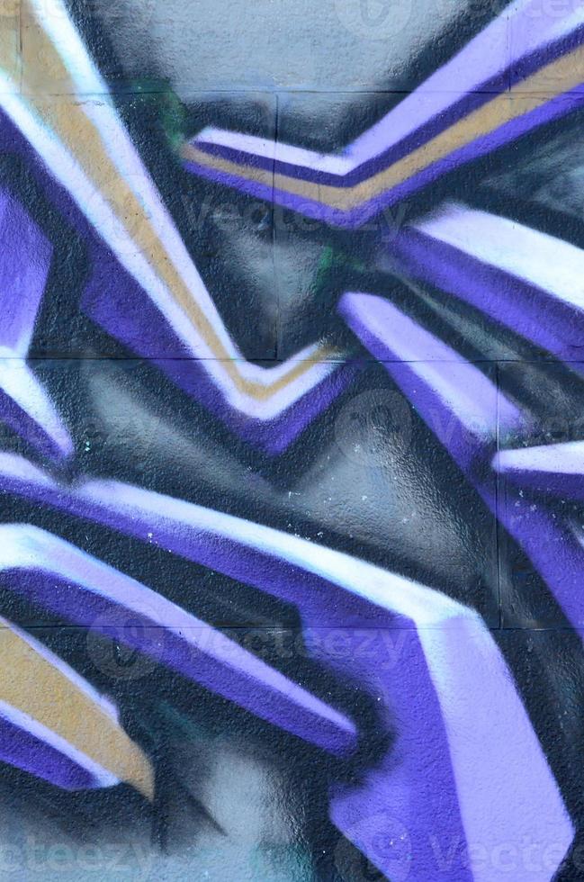 fragmento de desenhos de grafite. a parede antiga decorada com manchas de tinta no estilo da cultura da arte de rua. textura de fundo colorido em tons de roxo foto