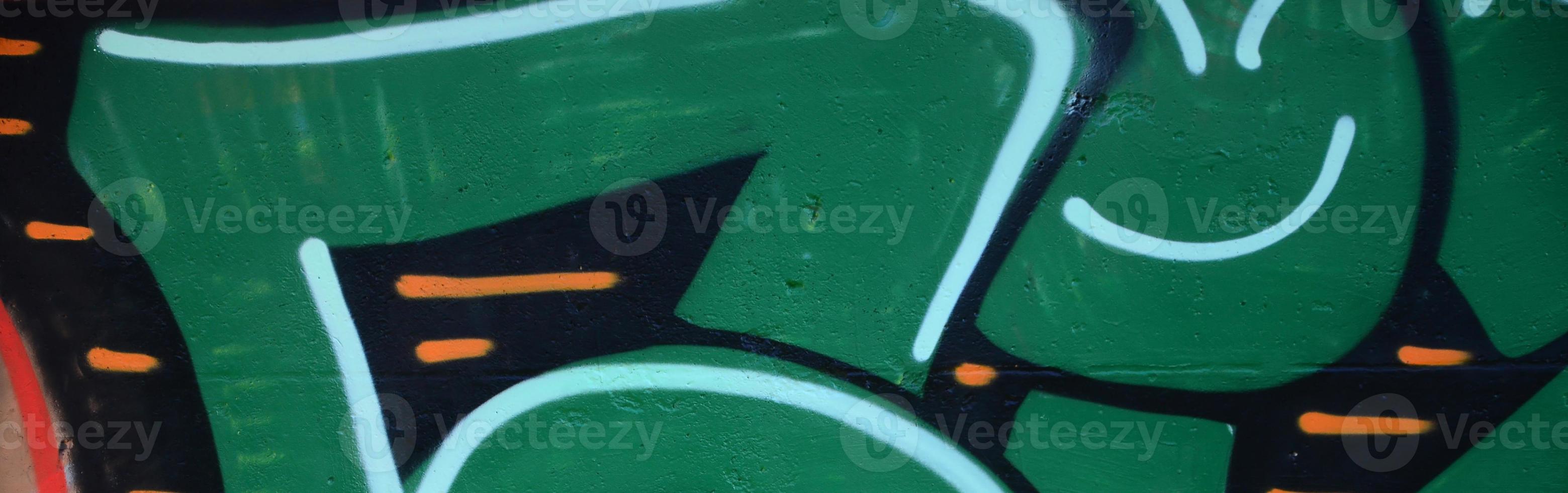 fragmento de desenhos de grafite. a parede antiga decorada com manchas de tinta no estilo da cultura da arte de rua. textura de fundo colorido em tons de verde foto