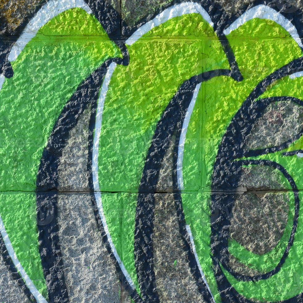 fragmento de desenhos de grafite. a parede antiga decorada com manchas de tinta no estilo da cultura da arte de rua. textura de fundo colorido em tons de verde foto