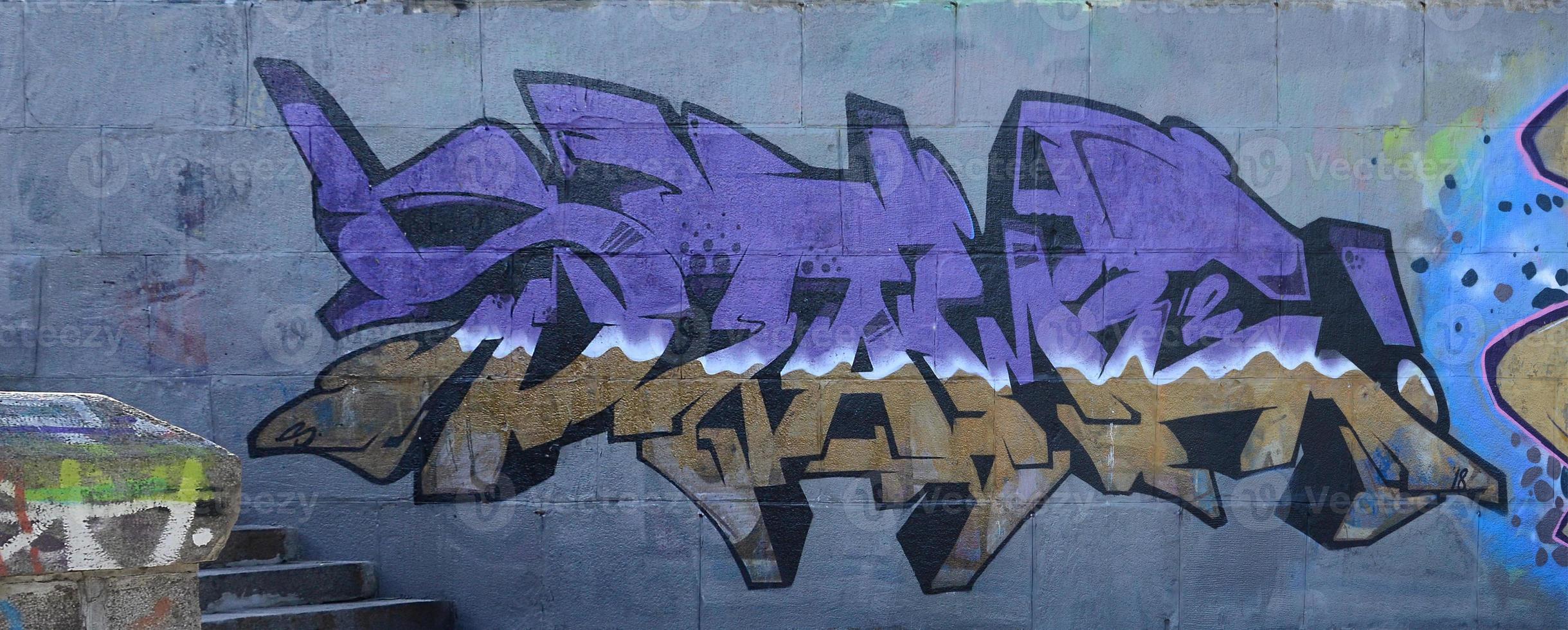fragmento de desenhos de grafite. a parede antiga decorada com manchas de tinta no estilo da cultura da arte de rua. textura de fundo colorido em tons de roxo foto