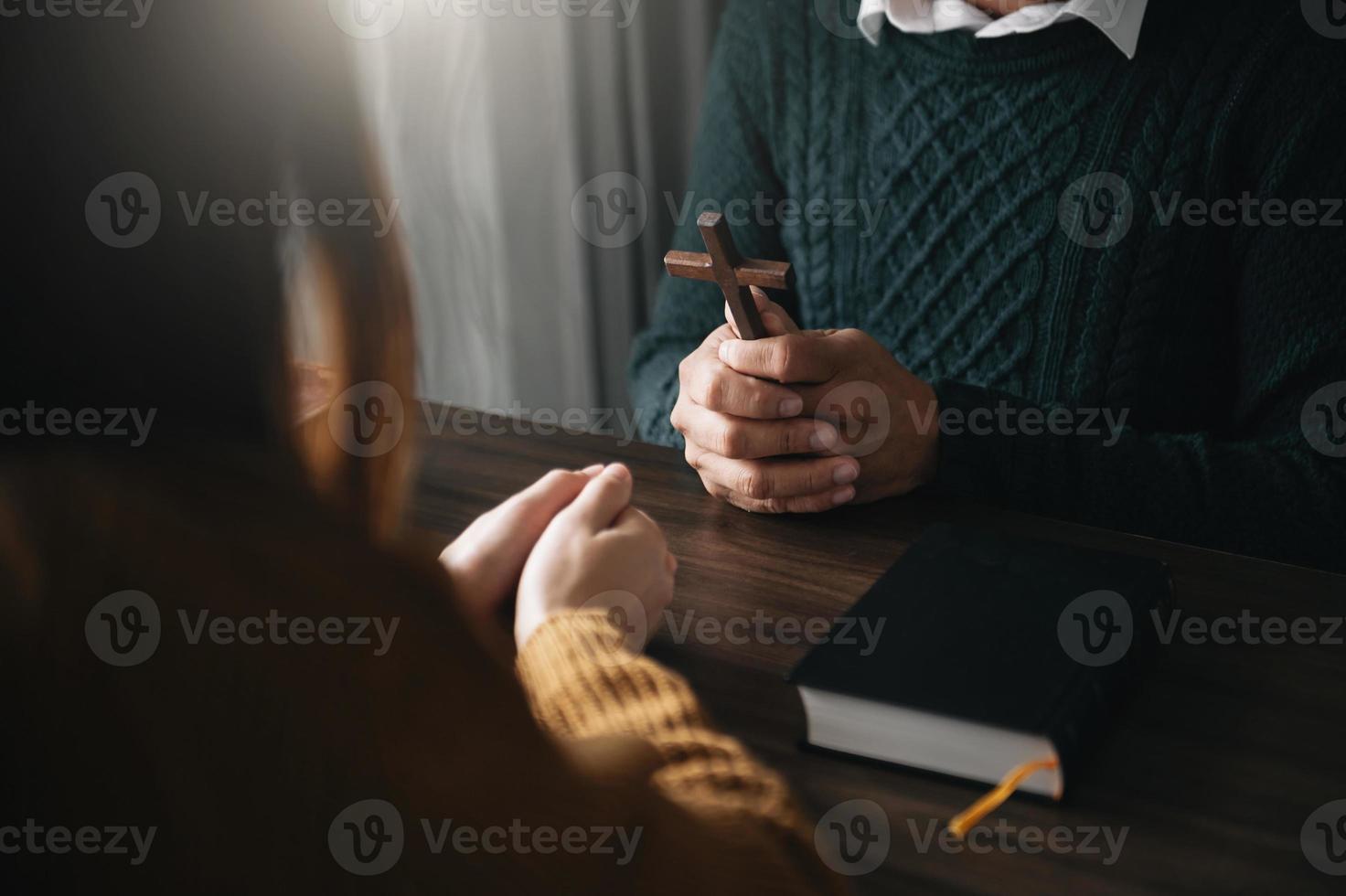 duas pessoas lendo e estudando a bíblia em casa e orando juntos. estudando a palavra de deus com os amigos. foto