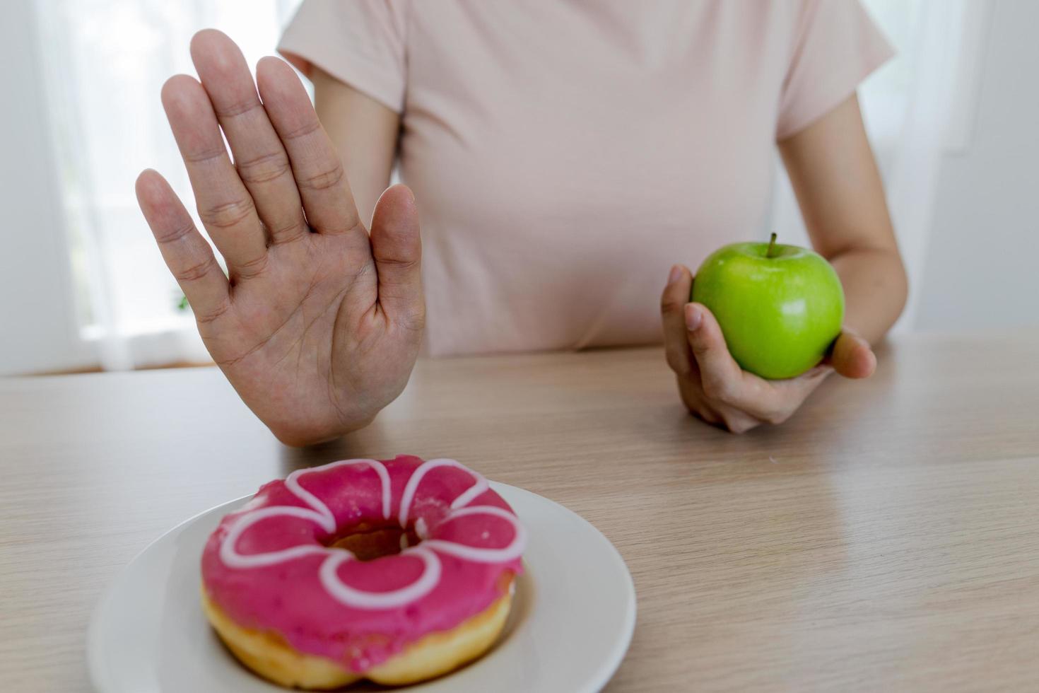 mulheres de corpo magro escolhem durante alimentos saudáveis e junk food, mulheres escolhem maçã verde para dieta. boa comida saudável. perda de peso, equilíbrio, controle, redução de gordura, baixas calorias, rotinas, exercícios. foto