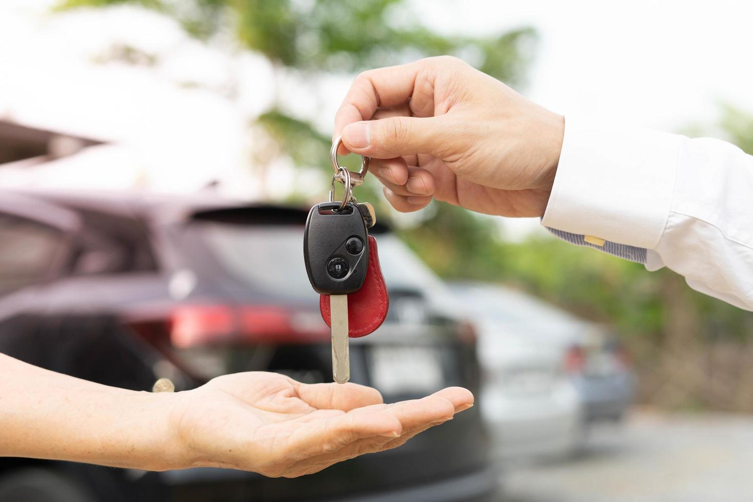 alugar, alugar carro, vender, comprar. o gerente da concessionária envia as chaves do carro para o novo proprietário. vendas, empréstimo de crédito financeiro, aluguel de veículo, seguro, aluguel, vendedor, negociante, prestação, negócio de cuidados com o carro foto