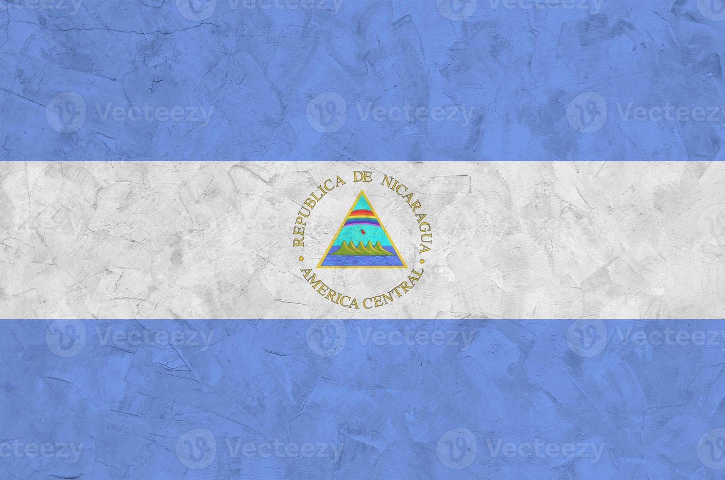 bandeira da nicarágua retratada em cores de tinta brilhante na parede de reboco em relevo antigo. banner texturizado em fundo áspero foto