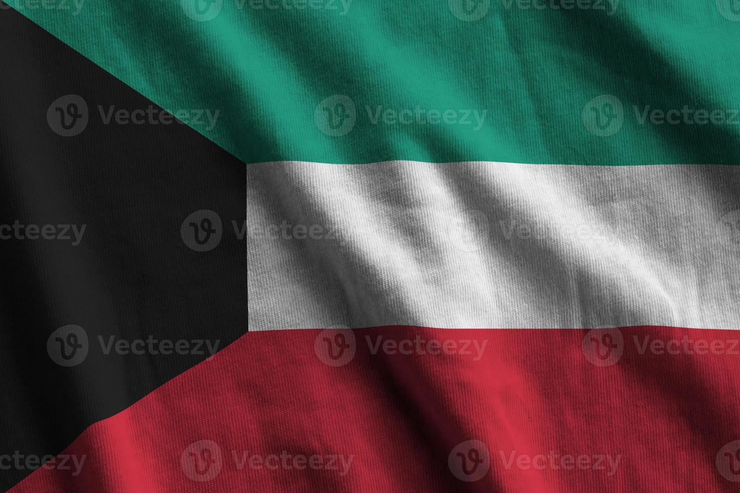 bandeira do kuwait com grandes dobras acenando perto sob a luz do estúdio dentro de casa. os símbolos e cores oficiais no banner foto