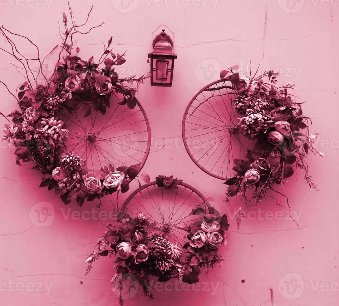objeto de arte urbana de decoração de rodas de bicicleta e flores na imagem da parede em tons de viva magenta, cor do ano de 2023 foto