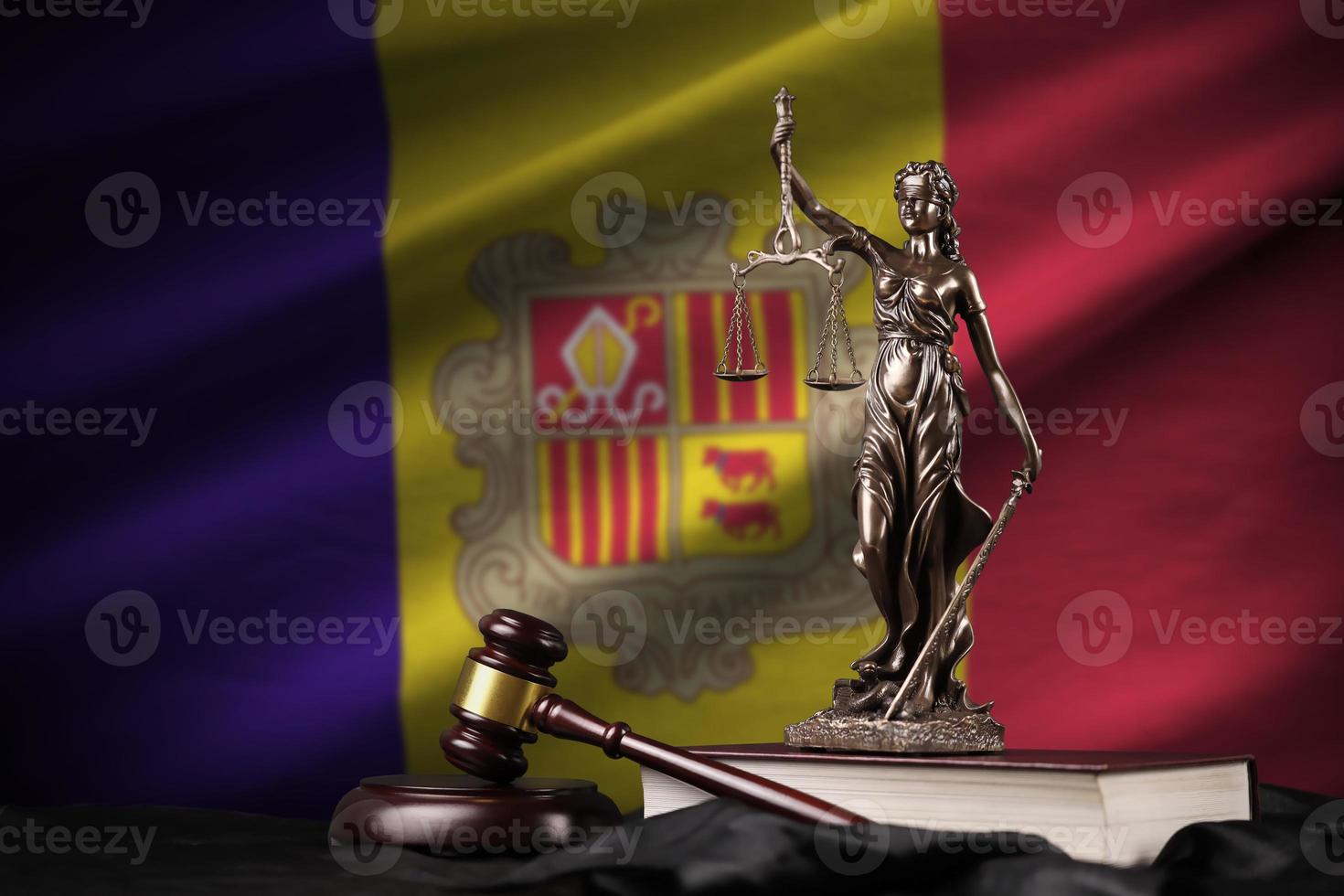 bandeira de andorra com a estátua da senhora justiça, constituição e juiz martelo na cortina preta. conceito de julgamento e culpa foto