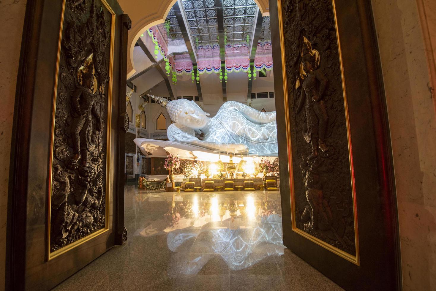 decoração do templo budista esculpida em mármore grande estátua de Buda branco dormir foto