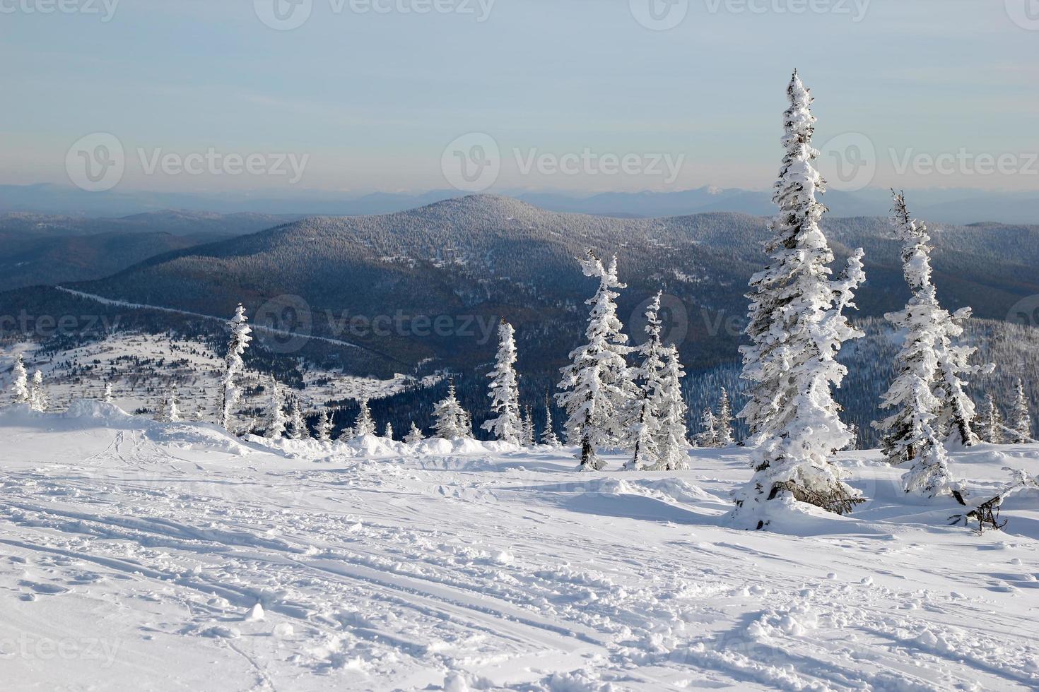 viajar para sheregesh, rússia. uma vista sobre a floresta de inverno e pista de esqui perto das montanhas. foto