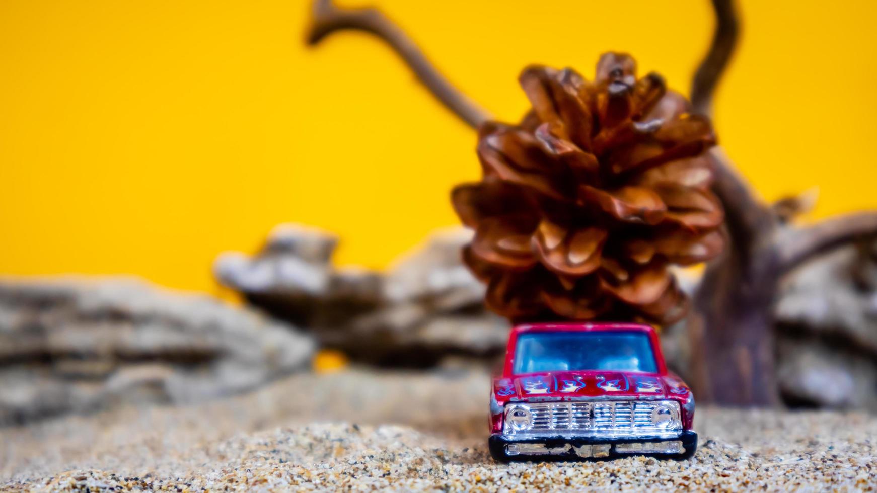 carro de brinquedo transportando pinhas em um fundo laranja foto