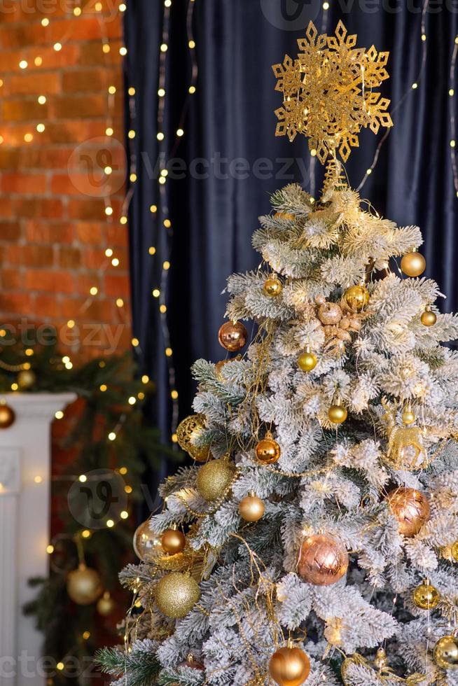 linda árvore de natal com guirlandas, bolas e brinquedos foto