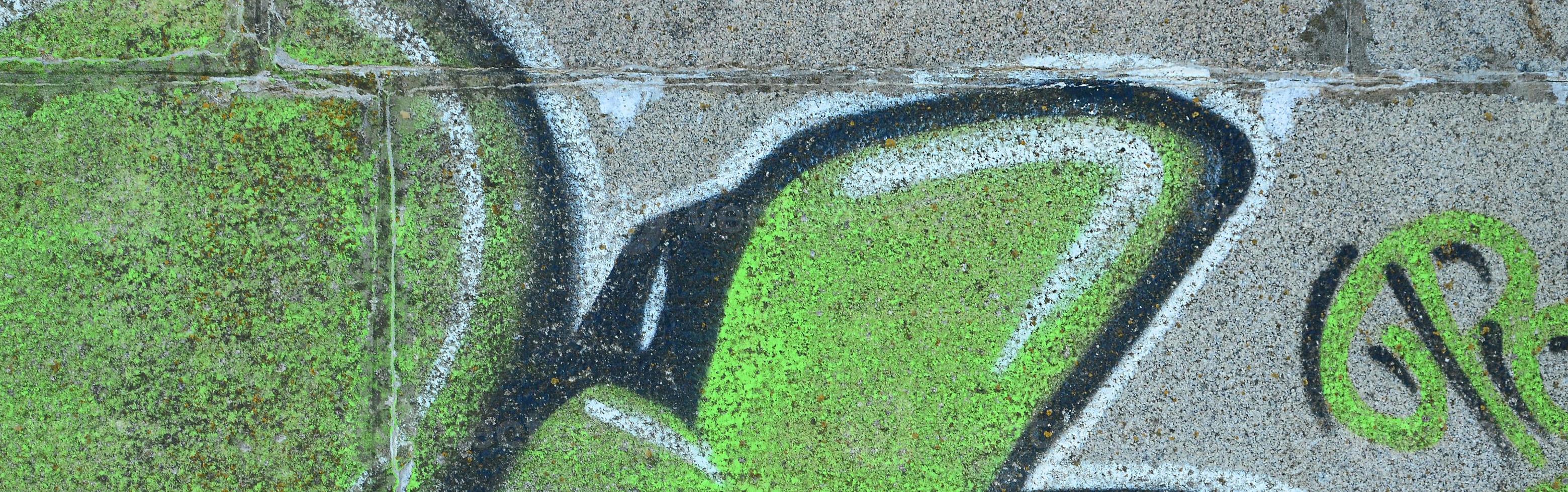 fragmento de desenhos de grafite. a parede antiga decorada com manchas de tinta no estilo da cultura da arte de rua. textura de fundo colorido em tons de verde foto