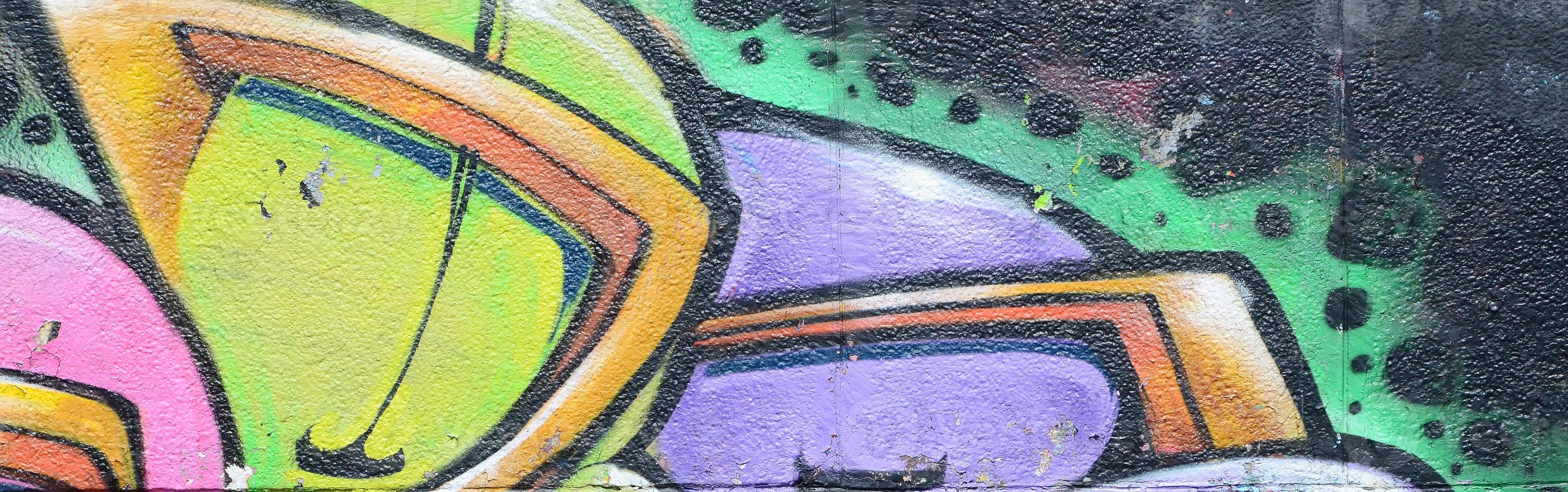 fragmento de desenhos de grafite. a velha parede decorada com manchas de tinta no estilo da cultura da arte de rua. textura de fundo multicolorida foto