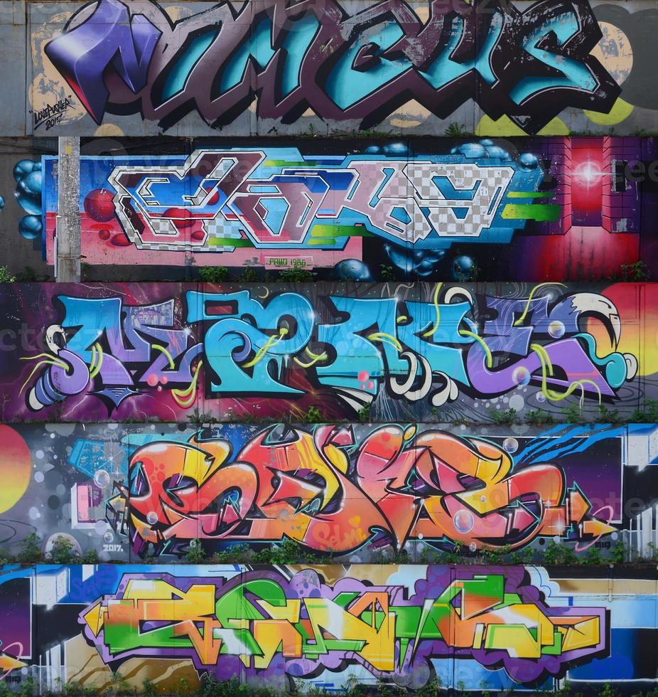 fragmento de desenhos de grafite. a velha parede decorada com manchas de tinta no estilo da cultura da arte de rua. textura de fundo multicolorida foto