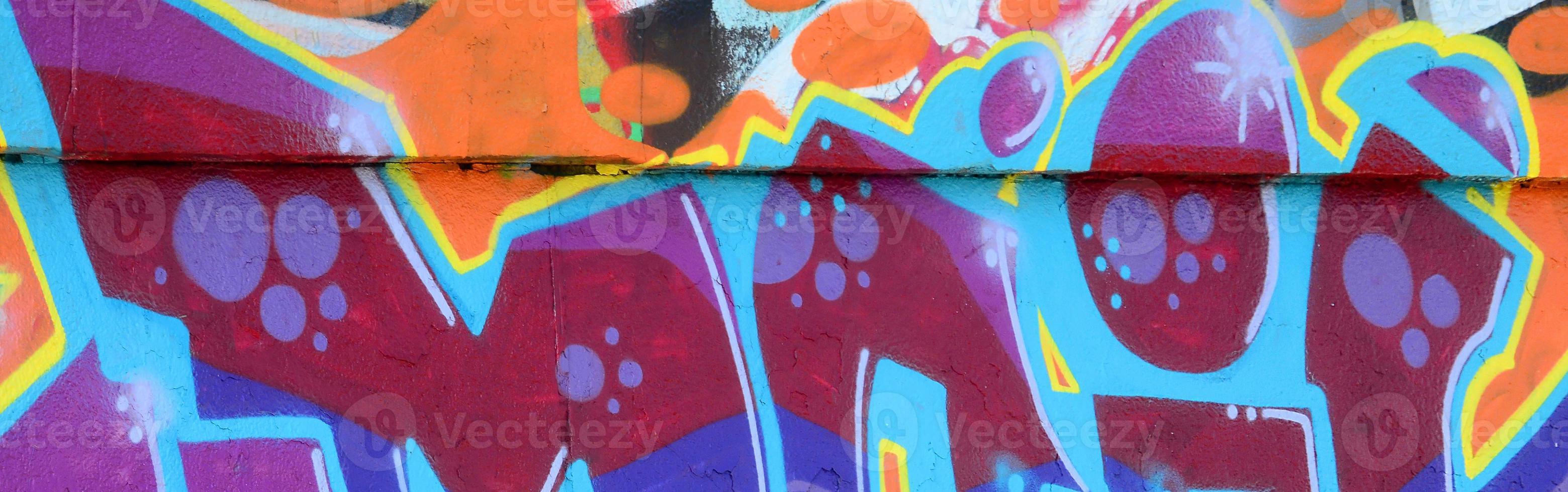 fragmento de desenhos de grafite. a parede antiga decorada com manchas de tinta no estilo da cultura da arte de rua. textura de fundo colorido em tons de roxo foto