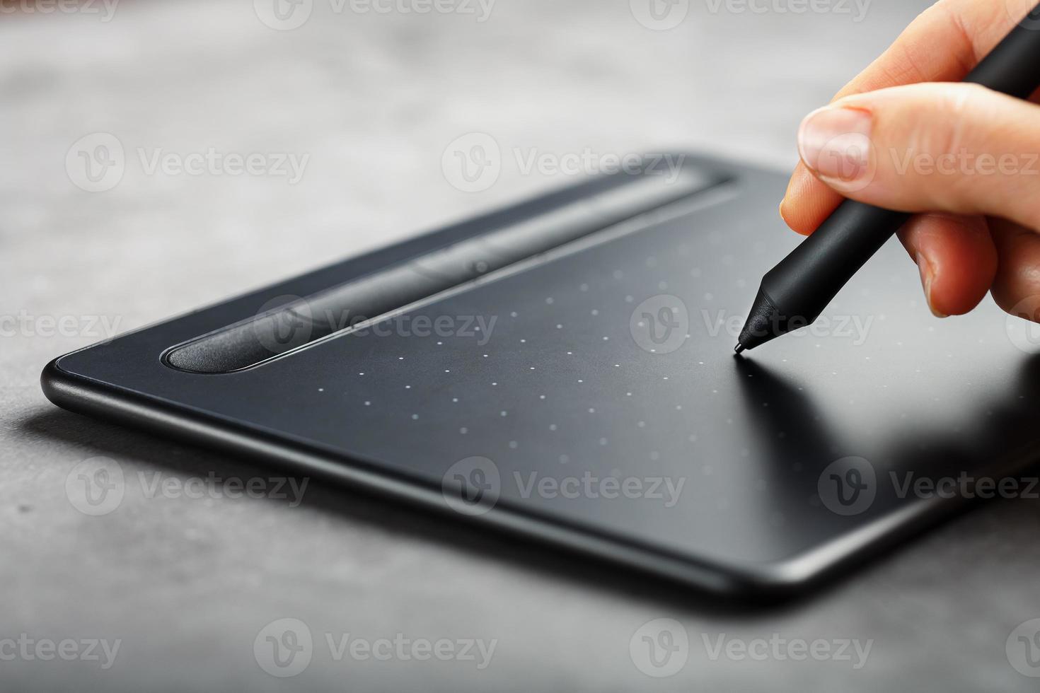 tablet gráfico com uma caneta nas mãos do designer, close-up. gadget para criatividade e trabalho foto