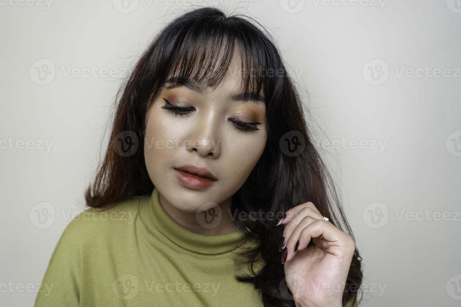 um rosto alegre de beleza da jovem modelo asiática vestindo top verde. tratamento facial de beleza para a pele, spa, conceito de saúde feminina. foto