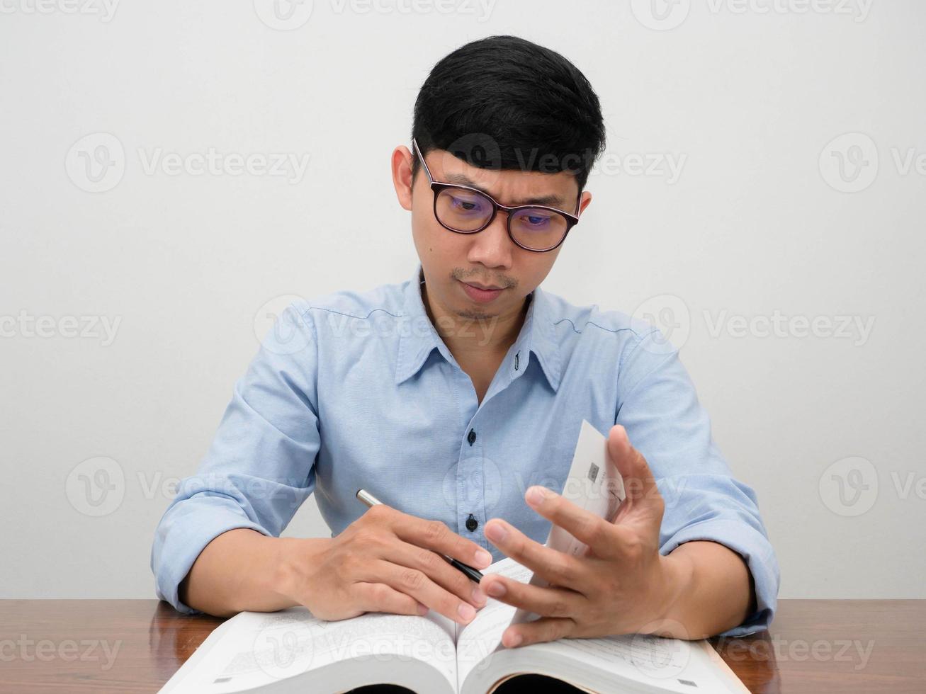 empresário asiático escrevendo sobre o livro sério trabalhando na mesa do local de trabalho foto