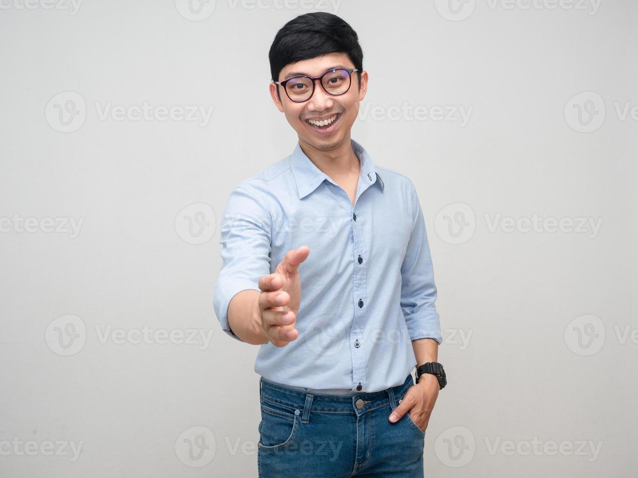 homem positivo usa óculos sorriso e gesto aperta a mão para você isolado foto