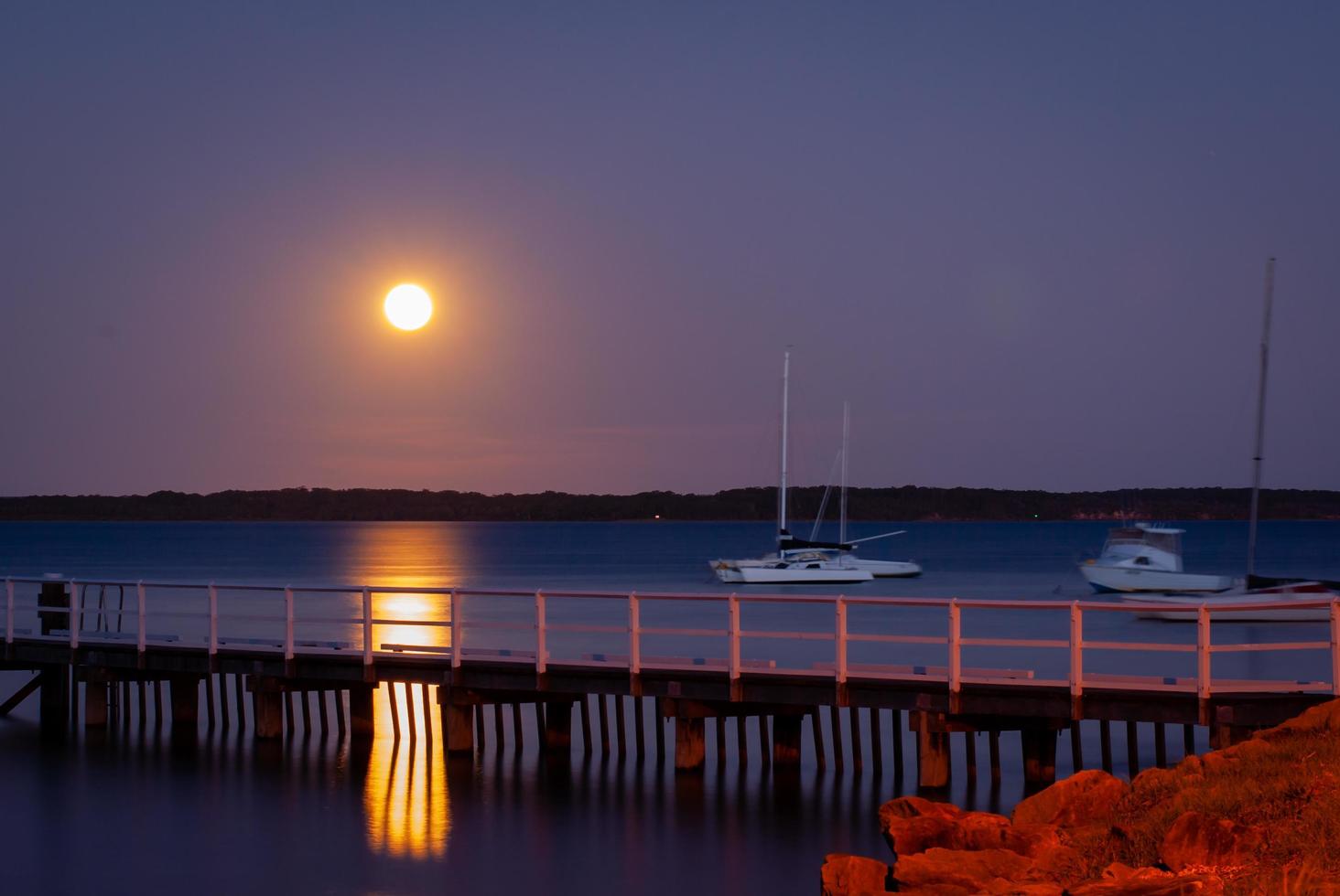 lua de longa exposição sobre o cais foto