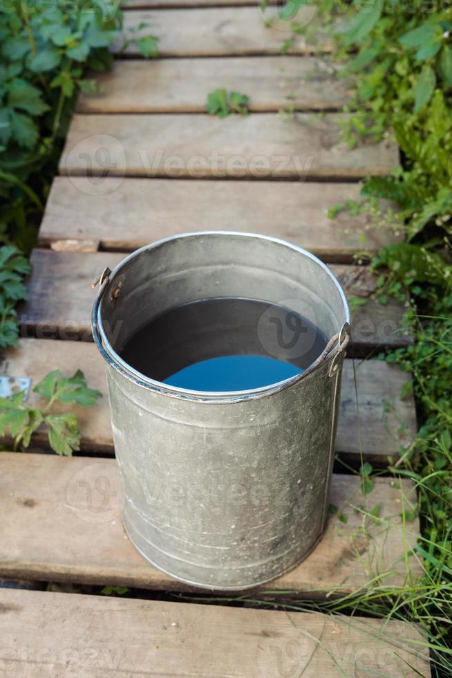 balde de ferro com água no país no verão, vista superior foto
