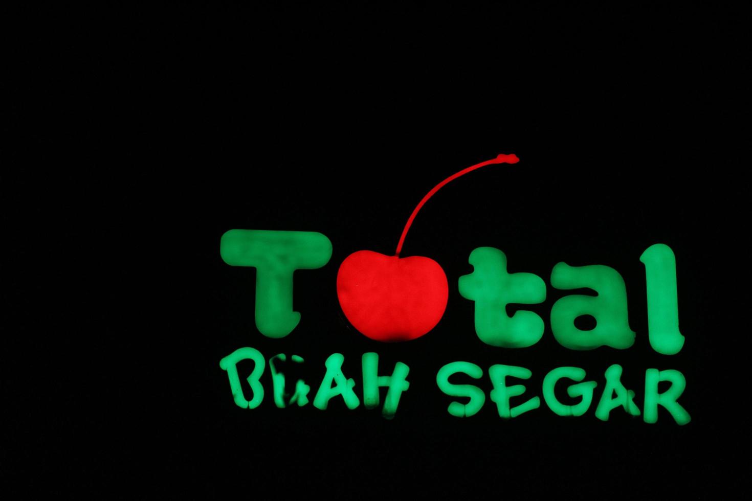 bekasi, indonésia em julho de 2022. o logotipo total buah segar brilhando intensamente à noite contra o céu noturno escuro. foto