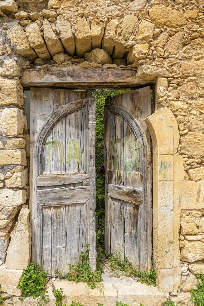 porta velha e ruinosa em uma antiga vila grega durante o dia foto