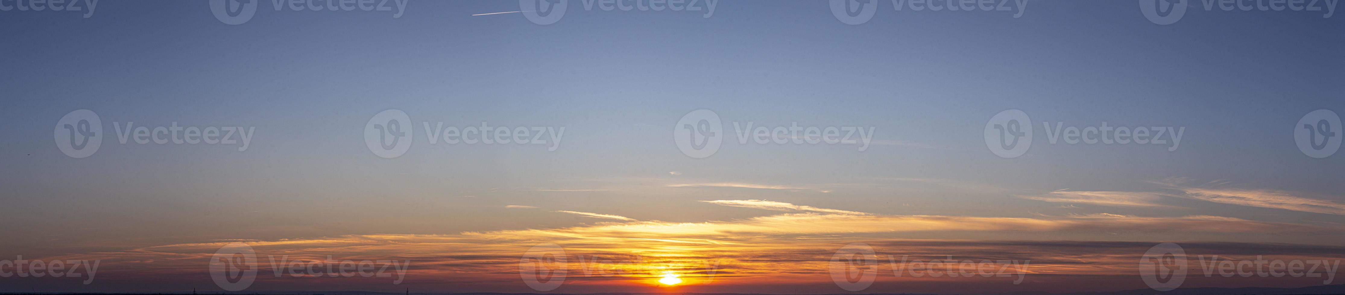 imagem do céu dramático e colorido com sol durante o pôr do sol foto