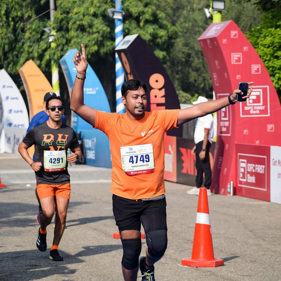 nova delhi, índia - 16 de outubro de 2022 - vedanta delhi meia maratona após covid em que os participantes da maratona prestes a cruzar a linha de chegada, meia maratona de delhi 2022 foto