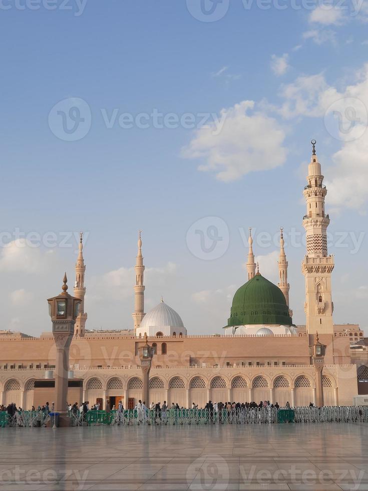 bela vista diurna de masjid al nabawi, cúpula verde de medina, minaretes e pátio da mesquita. foto