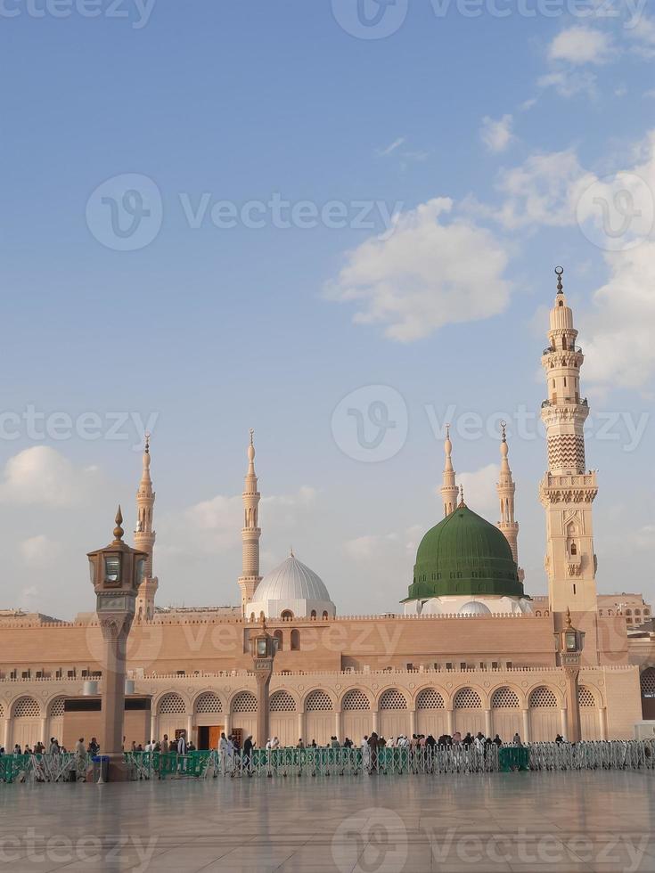 bela vista diurna de masjid al nabawi, cúpula verde de medina, minaretes e pátio da mesquita. foto