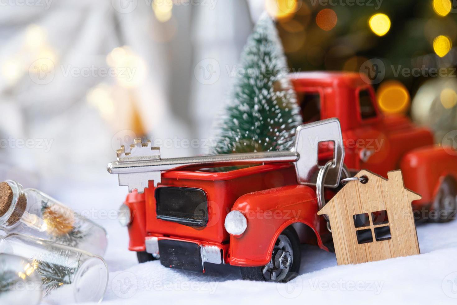 carro retrô vermelho com uma árvore de natal decora com a chave da casa na caminhonete para o natal. compra de uma casa, mudança, hipoteca, empréstimo, imóveis, clima festivo, ano novo foto