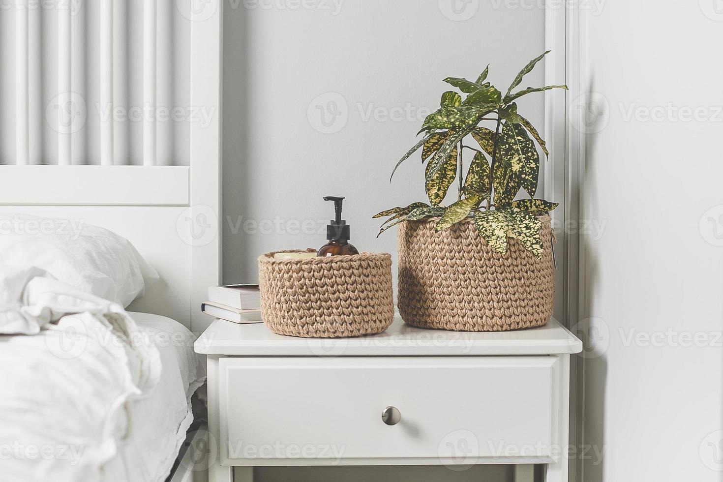 interior escandinavo em cores brancas. planta em casa na cesta de juta. conceito autêntico de estilo de vida. foto