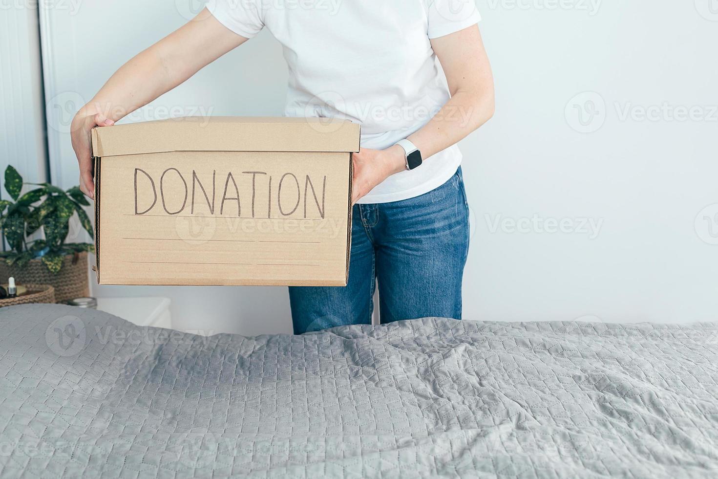 mulher segurando caixa de doação com roupas e itens pessoais. vida doméstica, estilo de vida foto