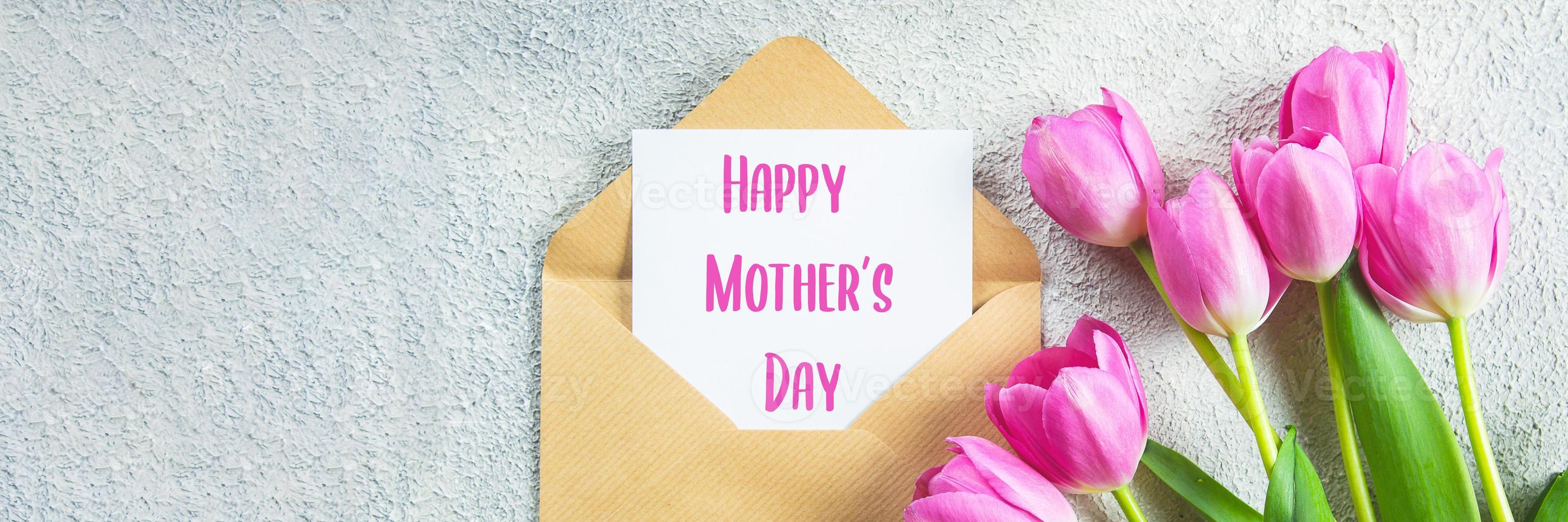 conceito de dia das mães. tulipas cor de rosa, cartão em fundo de concreto. postura plana. imagem do banner foto
