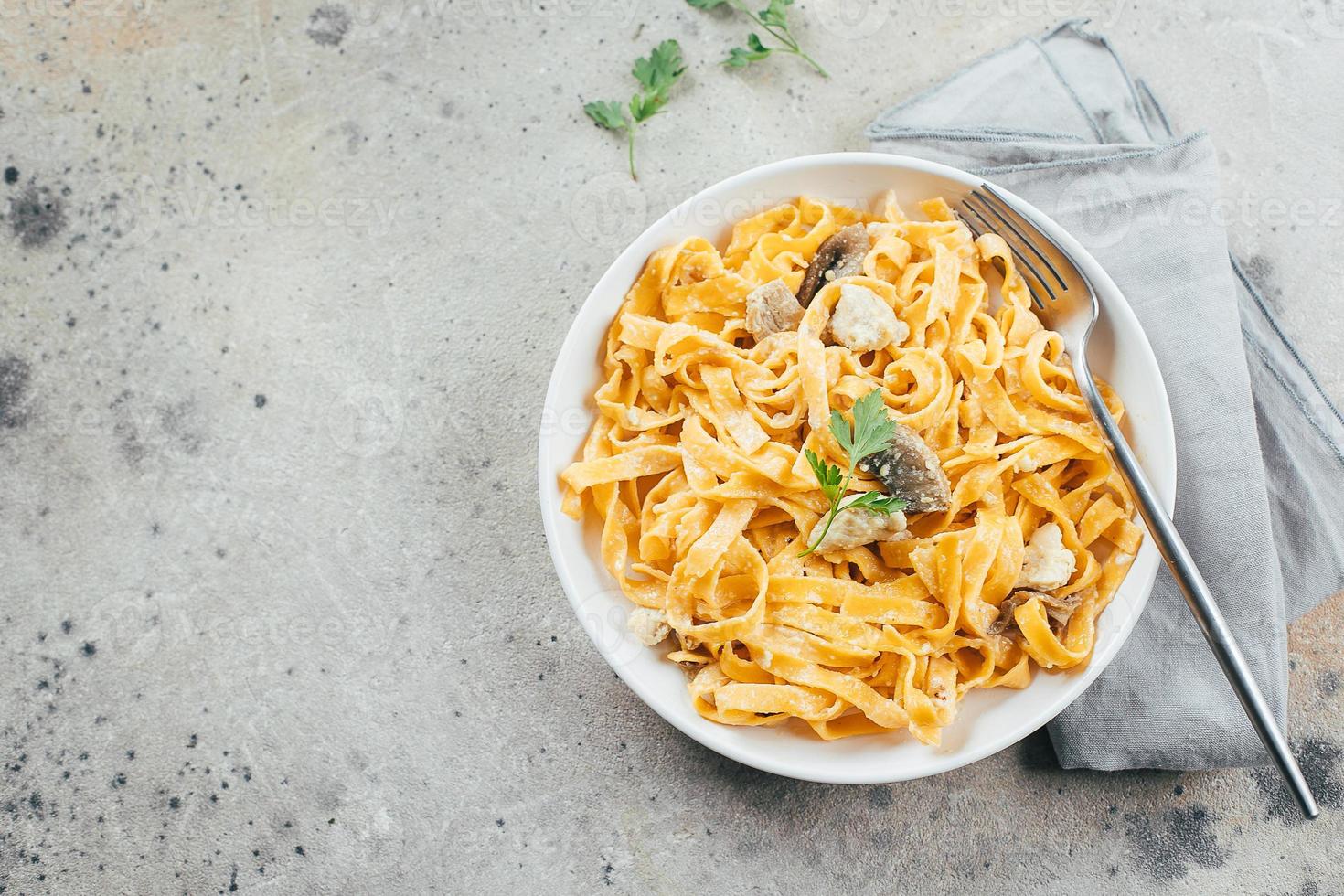 macarrão italiano fettuccine alfredo com frango, cogumelos e sause no prato. vista superior, copie o espaço foto