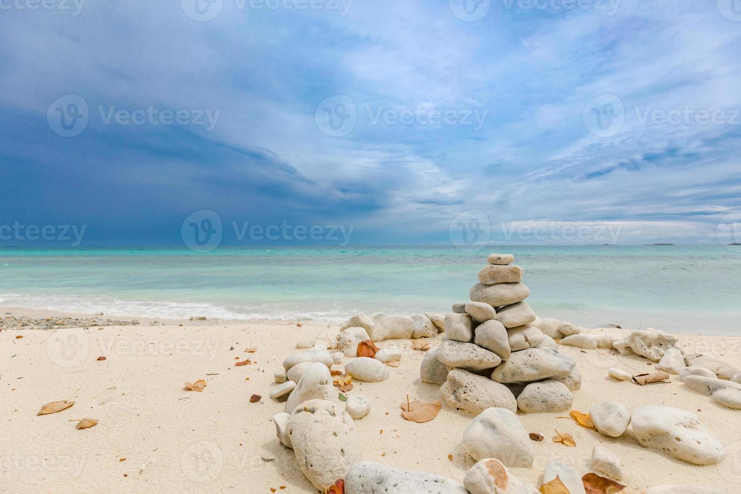 torres de pedras dolomitas equilibradas na praia em um dia nublado. pedra zen inspiradora e meditativa na praia foto