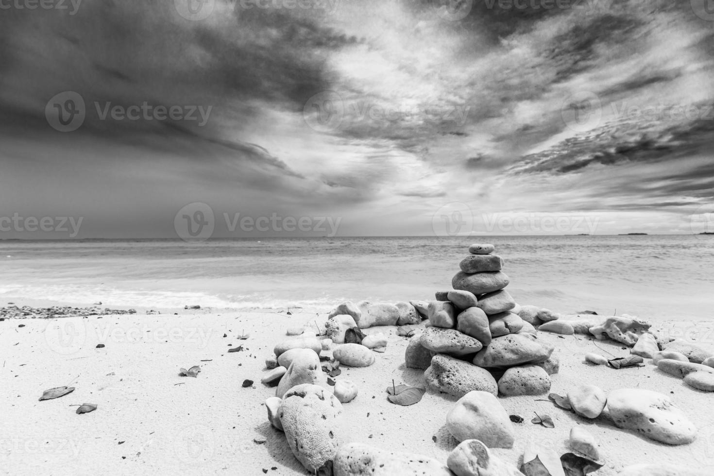 pilha de pedras, conceito zen, na praia. pilha de pedras na praia do mar contra o fundo dramático, zen, conceito de feng shui, foco seletivo. paisagem artística da natureza em preto e branco foto