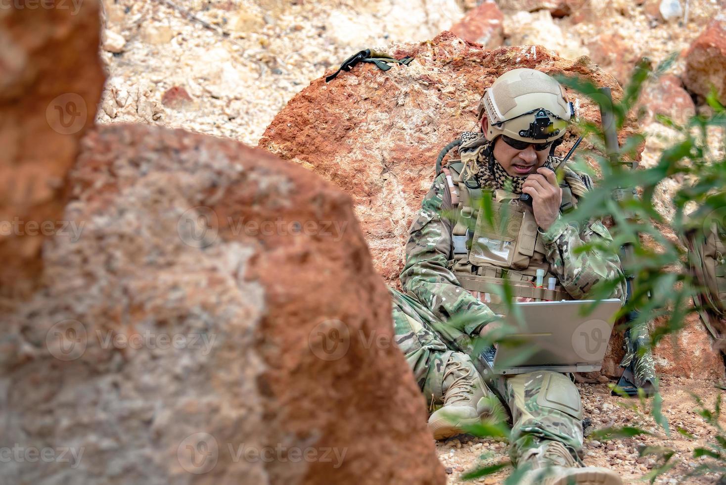 soldados das forças especiais em guerras no deserto, povo tailandês, soldado do exército usa laptop para ver mapa com satélite, usando rádio para comunicação durante operação militar foto