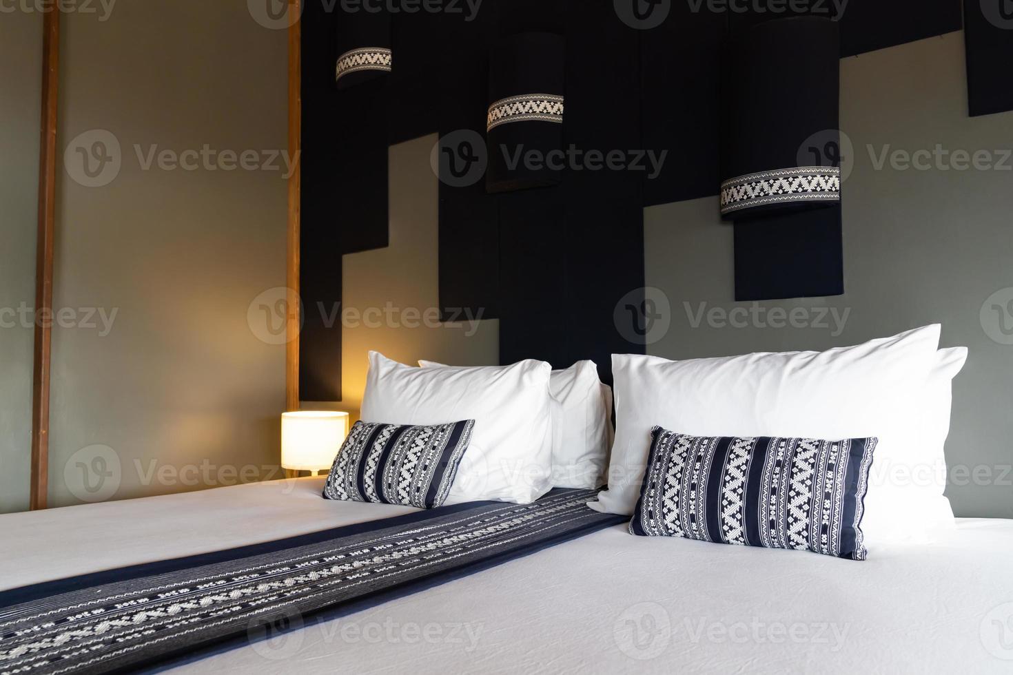 cama branca moderna e combinação de travesseiro azul escuro de estilo asiático de quarto de madeira vintage. foto