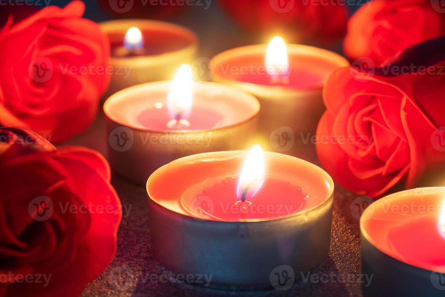 rosas vermelhas e velas acesas, close-up, cartão romântico. conceito de dia dos namorados. foto