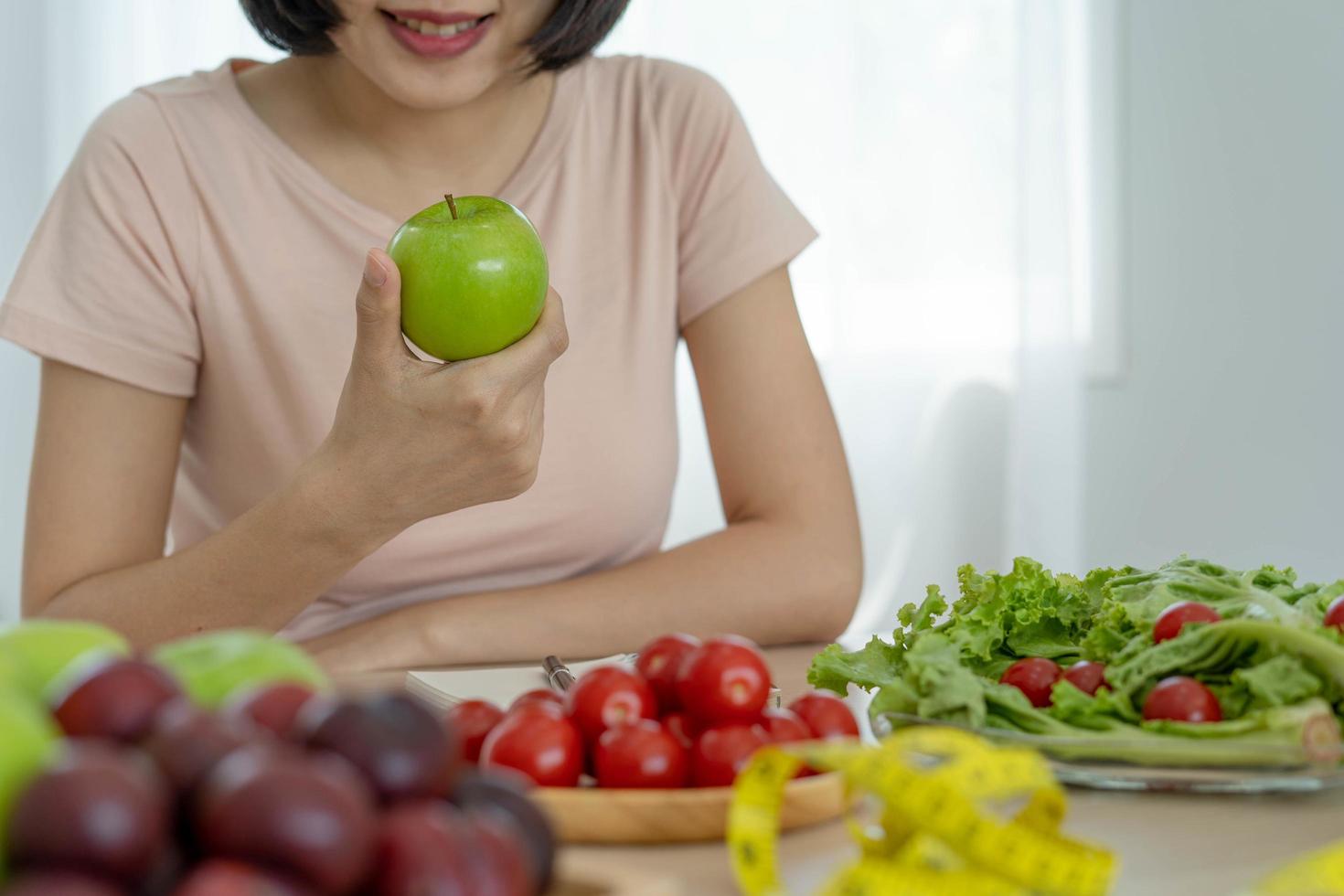 comida saudável e dieta cetônica. as mulheres planejam dietas para uma forma esbelta e saudável. mulher comendo maçã e legumes foto