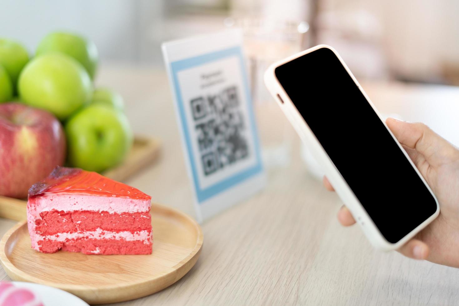 as mulheres usam o telefone para digitalizar o código qr para selecionar o menu de comida e acumular pontos. digitalize para obter descontos ou pagar por comida. o conceito de usar um telefone para transferir dinheiro ou pagar dinheiro online sem dinheiro. foto